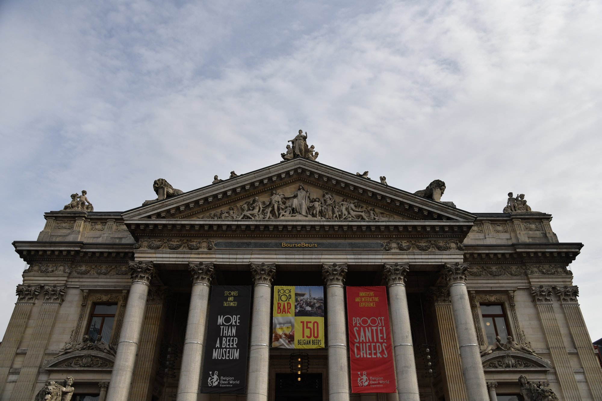 a neoclassical building with banners across its columns