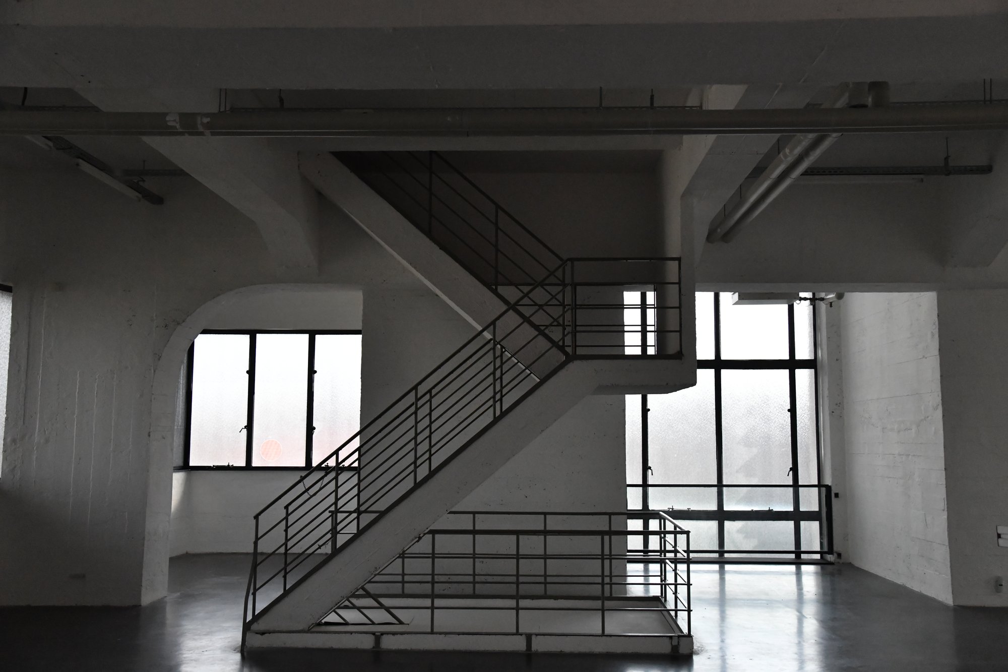 a staircase in a bright, empty industrial hall