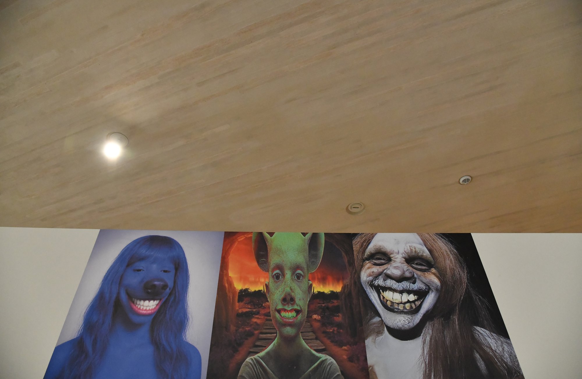 a painting of three grinning faces