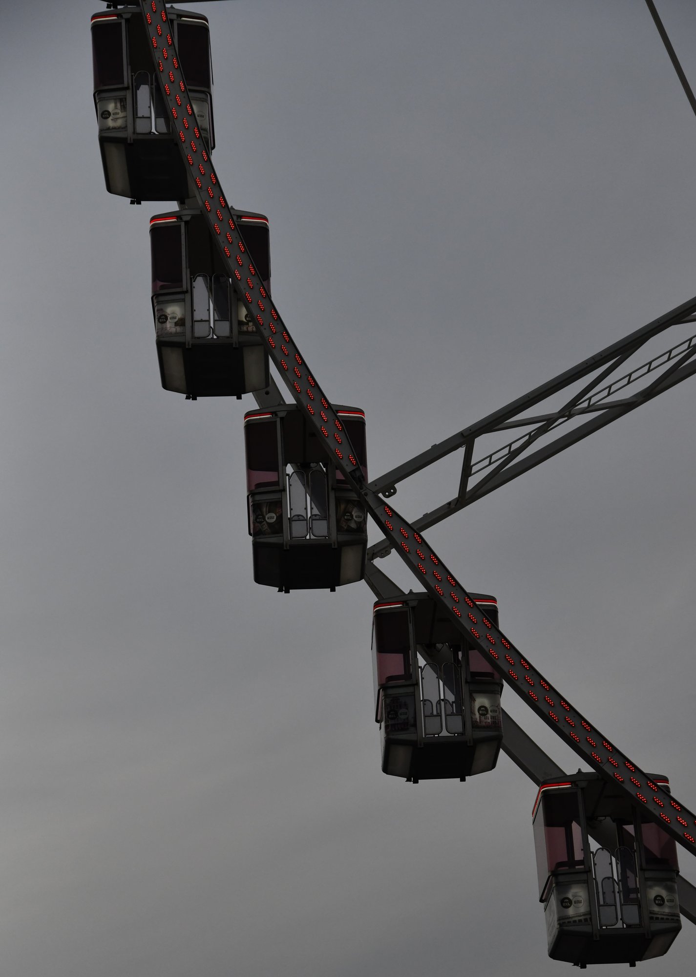 ferris wheel gondolas against a grey sky