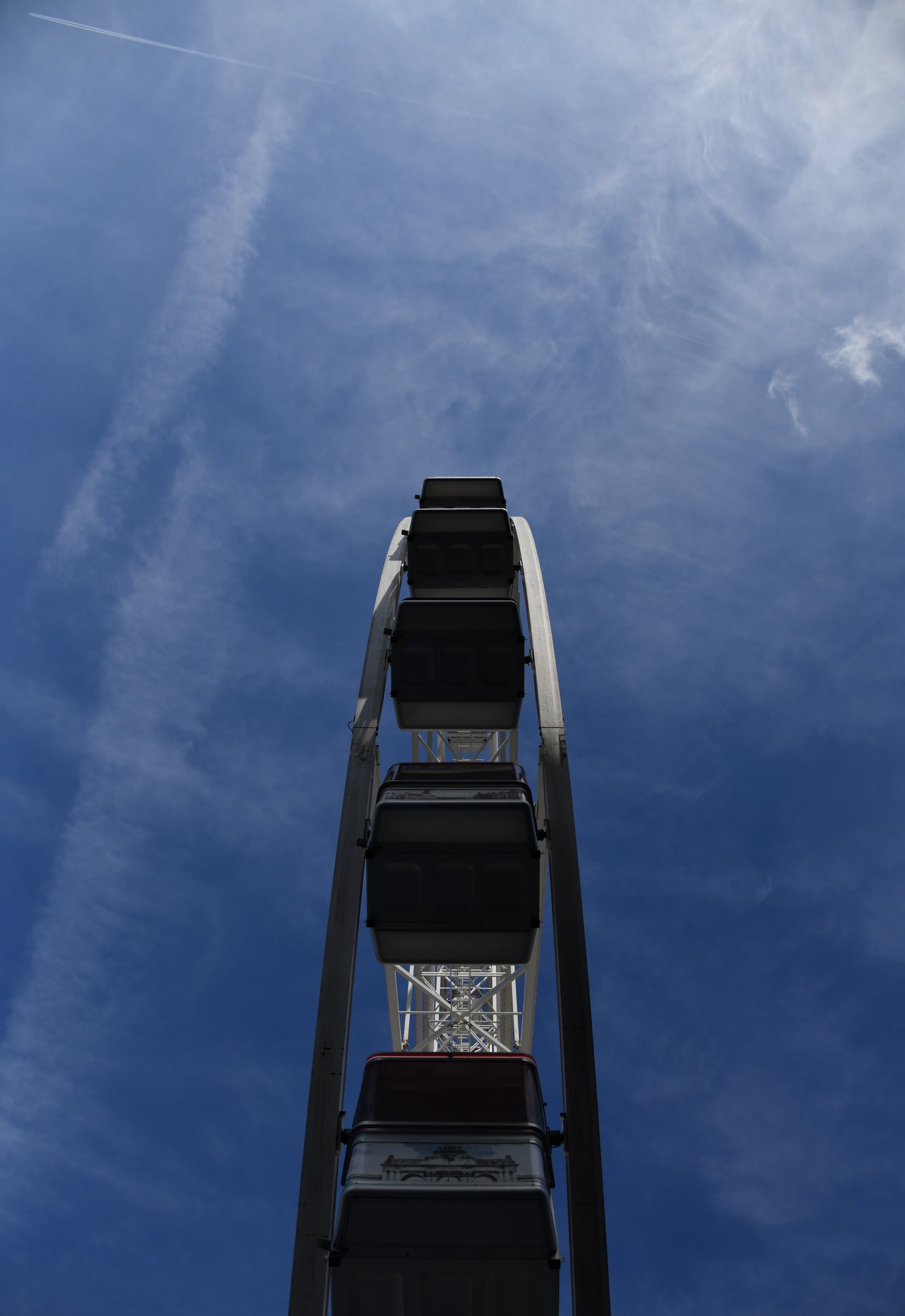 a ferris wheel from below, against a blue sky